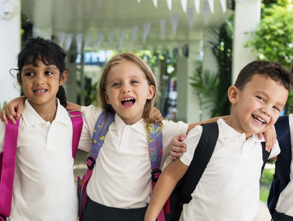 Young students smiling arm in arm.